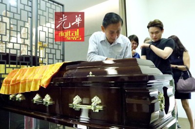 林武扬以爱儿的棺木前,多不舍,声声叮咛。