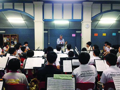 谈名光为槟城锺灵中学钢管乐团担任指挥。