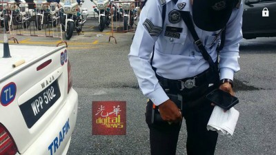 警车上还放着交警更换新卷罚单纸后留下的纸筒。
