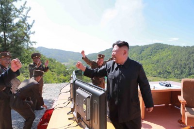金正恩在试射成功后笑逐颜开,随行人员欢呼雀跃。(法新社照片)