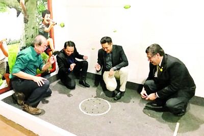 左起骆锦地、胡国强、刘荣鸿及菲力童心未泯玩玻璃弹珠的游戏。