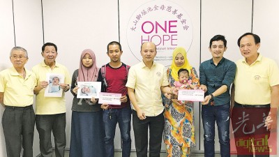 蔡瑞豪(左5)移交模拟支票予伊娜拉父母(左3及4)及涵楠父母(右2及3),许迪焜(左起)、洪明福及何永发(右)陪同。