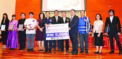 黄荣盛移交5000令吉模拟支票给新民华中下协财政李衍廷(右4)。