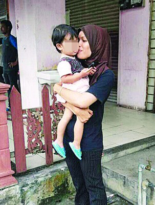 妇女见女儿无恙,才放下心头大石,并抱起女儿亲吻女儿小脸蛋。