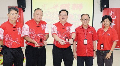 准拿督李兴前在总编辑郑彩凤及狮团团长邱智坚的陪同下颁发纪念品予拿督方万春及黎维雄教练。