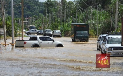 一辆四驱车因无法横渡水势高涨的道路而抛锚。