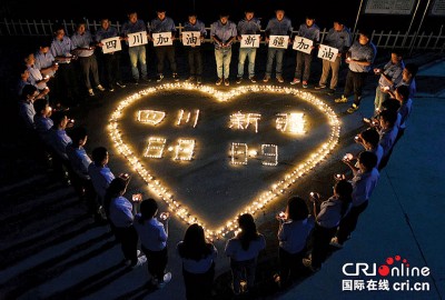 民众用蜡烛组成心形字样祈福,希望灾民早日渡过难关。