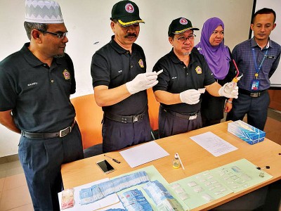 阿兹兰向媒体展示在逮捕行动中,吸毒者用以吸毒的用具。