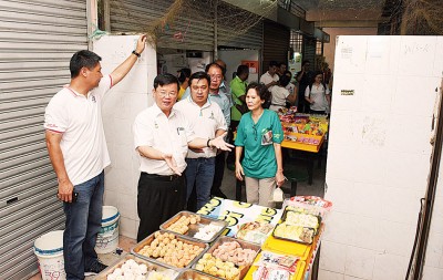 曹观友(左2起)、刘敬亿及黄伟益巡视五条路组屋区巴刹,向贩商了解当地情况。