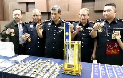 阿斯里(左3起)、陈德平示出警方所充公假勋章及假绶带等。