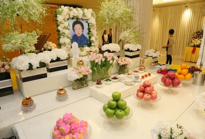 李金花灵堂以鲜花做主要布置,仪式采佛教进行。\