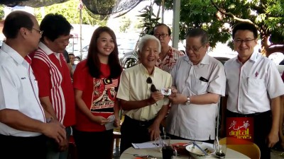 林吉祥(左5)在出席者陪同下,移交行动党党员证予黄康福(左4),左3为柔佛再也区州议员廖彩彤,右为刘镇东。