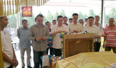 林冠英(前排左2)同人们持香祭拜死者,左为陈贵平;前排左起呢沈志强、李凯伦同陈衍财。