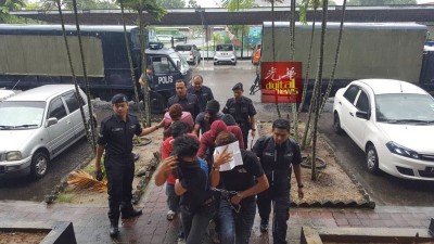 男被告从警车上被押入法庭。
