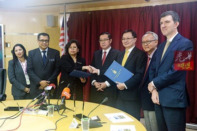 莎鲁(左3)和孙明福交换已签署合约,并由林冠英(左4)、董志兴和约翰等人见证。