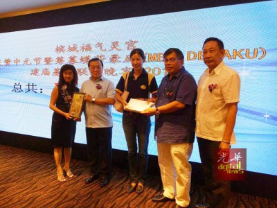 张誉发(右2)移交义款予大同建委会代表,左为总务林金水(左2)从街区代表郭燕美手中接领纪念品。