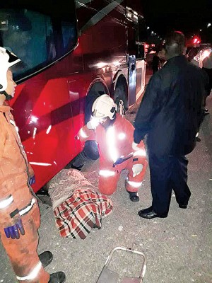 消拯人员将死者尸体自巴士车底移出。