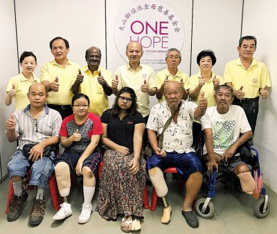 5名受惠者张初中(左起)、伍婉瑢、蒂威娜安、陈亚成及陈树冠穿上义肢后,开心与理事们合影,谢玉金(后排左起)、何永发、拿督斯里RA、蔡瑞豪、许迪焜、谢宝珍及余益荣。