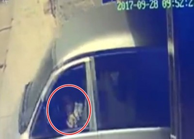 肇事轿车溜前时,男童(红圈示)因于驾驶席上。