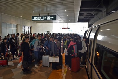 旅客在沈阳北站排队上车。(新华社照片)