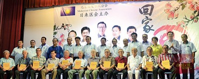 参与马华超过50年的12名老党员(前排)领取纪念品奖状后与领导人合影。左7与左6分别是廖中莱与李志亮,右5为梅振仁,右7与右8是梁荣光与范庆洲。