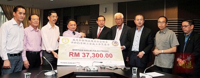 威省金银饰品商业公会及槟华兴和打金职工会移交赈灾捐款,左起刘俊辉、卢少发、陈银生、谢抺佑、林冠英、彭文宝、罗兴强、李家全等。