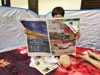 贪图为灾民张女士在读书《光日报》。