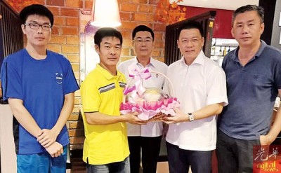 倪可敏捐赠水果礼篮予李天才父子和为她们一家人打气,右起刘长一与郑国霖。