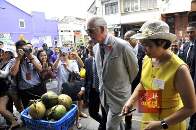 王储途经打铜仔街,公众不仅围观及追拍,更不断告诉王储要喝椰水解暑。