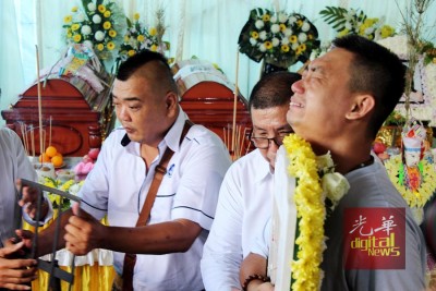 難掩對兒女不舍,林瑞木抱著兩人遺照落淚。