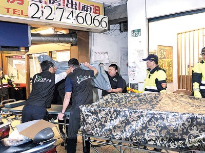 殡葬业者将死者遗体移离现场。