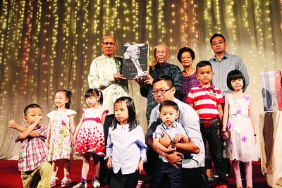 邱吉寿(立左2)每当夫人杨黛丝(立右2)些微名男、些微名孙子和另佛学院幼儿院孩子陪同下,以及拿督安华(立左1)一齐主持自传推介。