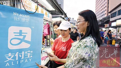 纽冷老字号卤肉小贩阿海使用支付宝。
