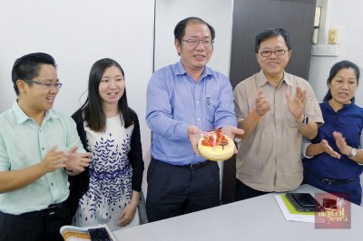 黄伟益(中)服务中心职员在记者会后替其庆生,他许下“不要在反贪会过”的生日愿望。右2和左1分别是黄泉安和槟岛市议员王宇航。