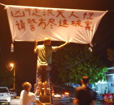 愤愤不平的柔府村民在王国安丧府前入口挂起布条。