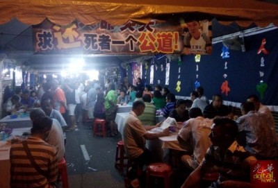 丧府帐蓬挂有横幅,尽显大家心中的不满。