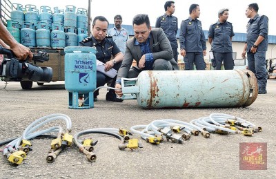 礼祖安示范非法商家如何使用输送管将家用煤气过渡至工业煤气桶。