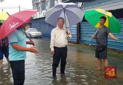 (左起)谢金荣、陈宗兴到巡视灾区,旁为甘榜德苏顺居民。