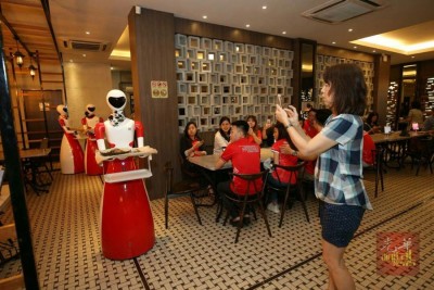 女神帮机器人侍应生“出动”,吸引不少顾客竞相拍照。