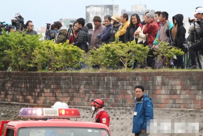 许多民众与搜救人员站在一起观看救灾进度。