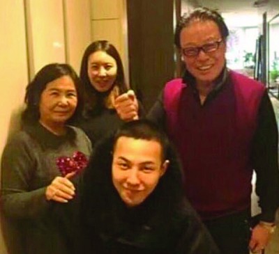 张罗着平头的GD跟老人和姐姐合照。