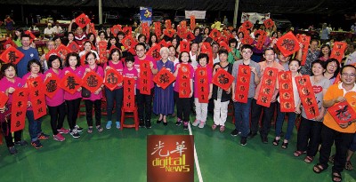 沈志强(右10自从)、章瑛、陈欣瀛以及具有参加者一起手举新春对联,贺大家春节快乐。
