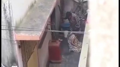老妇挥棍拍打女子。