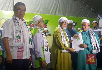 法兹（右）移交新党员入党表格予哈迪阿旺，左起范清渊、伊党峇东埔区部主席奥马哈山。