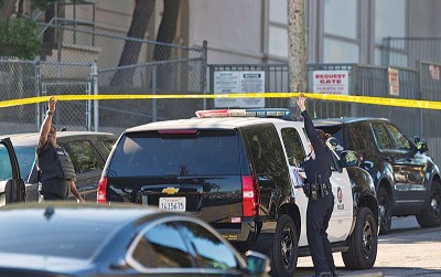 警员将封锁线拉起让警车进入校区。