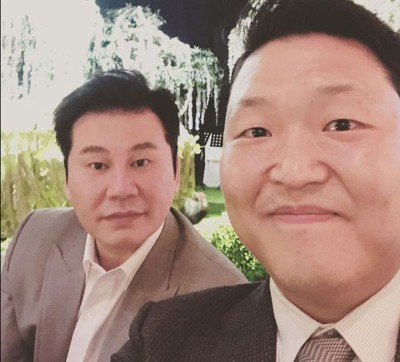 “YG娱乐”老板梁铉锡(左)与PSY合影。