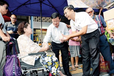 郑来兴(右起)、曹观友赠送杯子蛋糕予妇女。
