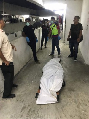 死者的遗体在包裹后,准备送往太平间停放待解剖。