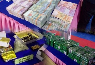 警方周六在记者会出示在行动中搜到的冰毒、炼毒工具、一把半自动手枪、子弹、金饰和多国纸钞。