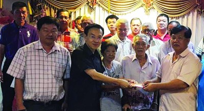 陈栋良(左2)在理事会成员联合见证下,移交1000令吉捐款予曾庆健。